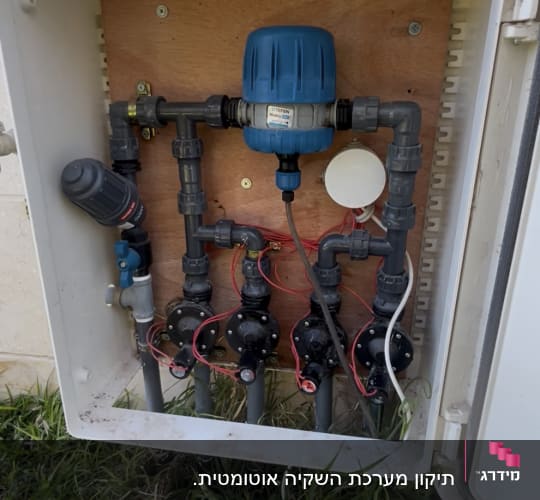 מערכת השקיה עם צינורות ושסתומים בגינה